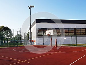 Modern basketball court in the courtyard of primary school. Multifunctional children`s playground with artificial surfaced fenced