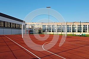 Modern basketball court in the courtyard of primary school. Multifunctional children`s playground with artificial surfaced fenced