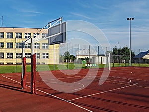 Modern basketball court in the courtyard of primary school. Multifunctional children`s playground with artificial surfaced fenced