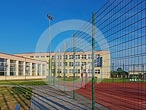 Modern basketball court in the courtyard of primary school. Multifunctional children`s playground with artificial surfaced fenced