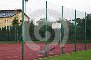 Modern basketball court in the courtyard of primary school. Multifunctional children`s playground with artificial surfaced fenced photo