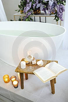 Modern bath room and spa center on the white tub wooden table