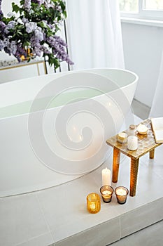 Modern bath room and spa center on the white tub wooden table