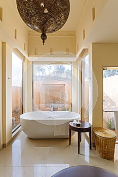 Modern bathroom area with bath tub and sofa inside in the morning at Abu Dhabi, UAE