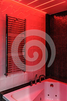 Modern bathroom with freestanding bathtub, modern taps and red LED ambient lighting