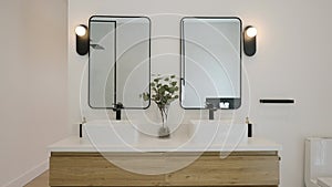 Modern bathroom interior in white color and minimalist style with two rectangular bowl sinks on top of wooden counter