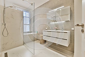 Modern bathroom with light furniture and shower