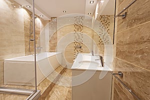 Modern bathroom in neutral colors with a shower and bathtub next to a mirror