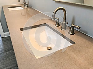 Modern bathroom with quartz countertop, two sinks and faucets with stone floor