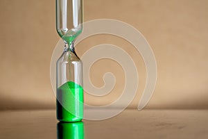 Modern beautiful green hourglass with bright background for copy space. Hourglass time passing concept for business