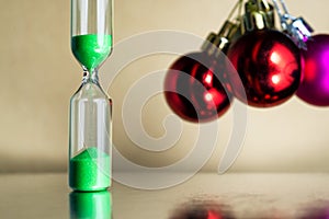 Modern beautiful green hourglass with christmas or xmas and new year balls.