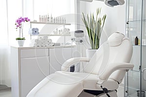 Modern beauty salon interior with a comfortable white chair, clean towels, and orchid plant, with a serene atmosphere