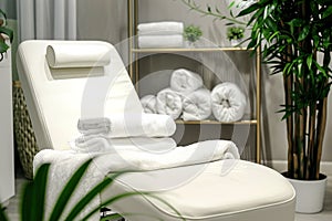 Modern beauty salon interior with a comfortable white chair, clean towels, and orchid plant, with a serene atmosphere