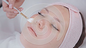 modern beauty treatment in cosmetology clinic, aesthetician applying mask on woman face