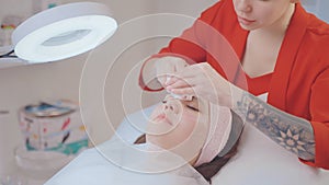 modern beauty treatment in medical clinic, cosmetologist cleansing facial skin of female patient