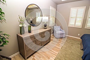 Modern Bedroom With Circular Mirror & Wooden Dresser