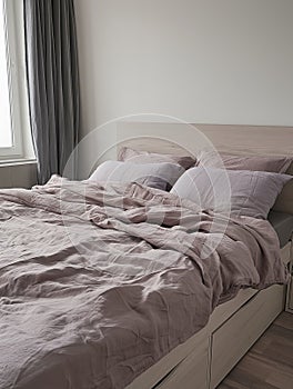 Modern bedroom interior with lavender bedding on wooden bed, minimalist style