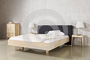 Modern bedroom interior in minimal stye white bedside table and lamp. Wooden bedroom interior.
