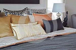 Modern bedroom interior with orange and gold pillows on bed