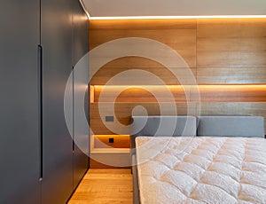 Modern bedroom interior with wooden walls and warm ambient light