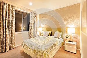 modern bedroom with king size bed illuminated by table lamps