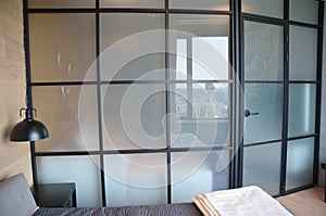 Modern bedroom zoning with glass wall.  Modern bedroom interior with cozy glass wall and door photo