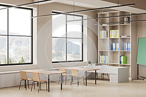 Modern beige classroom interior with desk in row and shelf near window