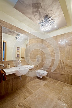 Modern beige room with toilet, sink, mirror and bidet