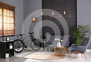 Modern bicycle and comfortable sofa in living room interior