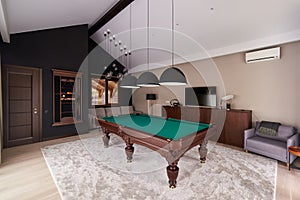 Modern billiard room with a beautiful table and large windows