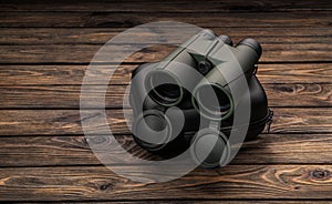 Modern binoculars. An optical instrument for observation at long distances. Dark wooden back