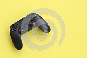 Modern black gamepad on yellow background. Esports and cyber sport tournament concept