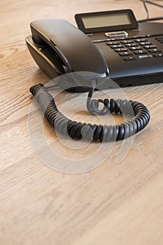 Modern black phone on wooden desk