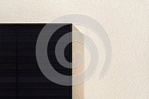 Modern black solar panel installed on white facade of modern house.