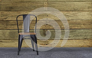 Modern black steel chair in wooden room interior concrete