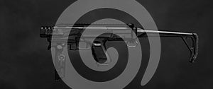 Modern black submachine gun on a black