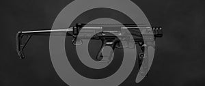Modern black submachine gun on a black