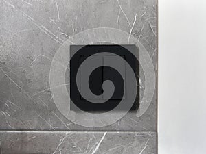 A modern black switch on a white wall background