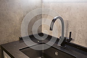 Modern black water tab and square sink with concrete wall