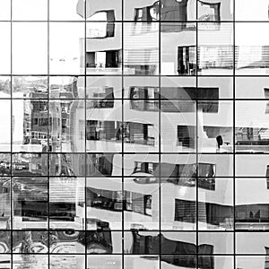 Modern black and white building reflected on glass facade