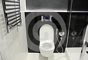 A modern black and white toilet, bathroom with a wall mounted toilet bowl, bidet shower, bidet sprayer and heated towel rails,
