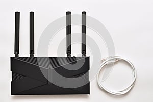Modern black wi-fi 6 router on a white background with ethernet cable