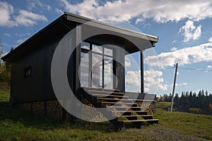 Modern black wooden house with big windows on Carpathian mountains in Ukraine with copy space