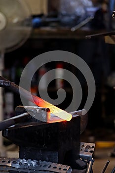 Modern blacksmith working in his shop