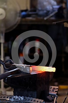 Modern blacksmith working in his shop