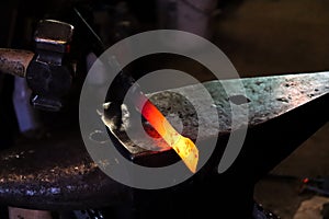 Modern blacksmith working in his shop