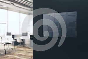 Modern blurry office interior with empty glass banner with reflections on dark wall. 3D Rendering