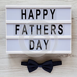 Modern board with `Happy Fathers Day` words over white wooden surface, top view. Overhead, from above, flat lay. Father`s day