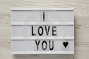 Modern board with text `I Love You` on a white wooden background, top view. Flat lay, overhead. Valentine`s Day 14 February