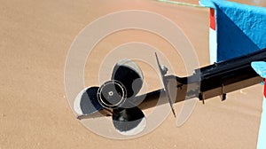 Modern boat propeller on beach sand background.